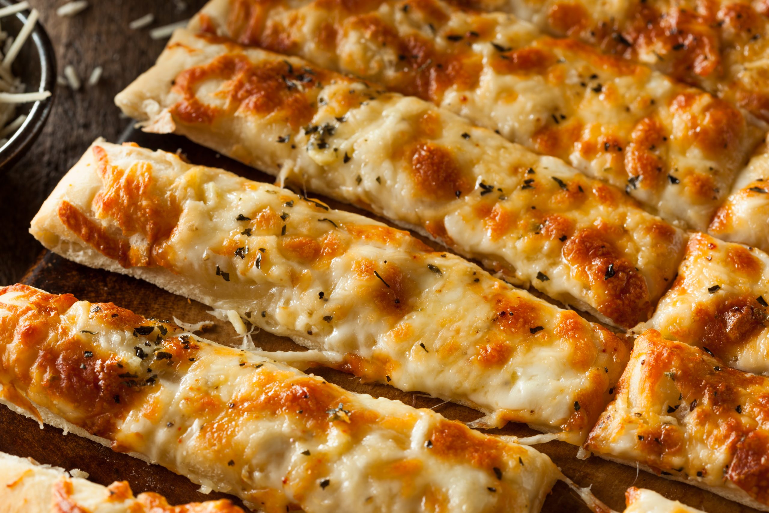 Pizza dough with garlic butter and melted cheese, cut in strips.